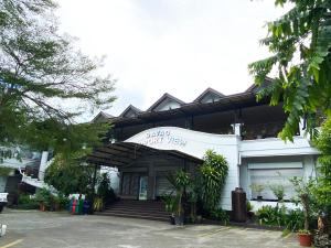 Davao Airport View Hotel في مدينة دافاو: مبنى أبيض مع علامة تنص على أن ديفيد انسحب