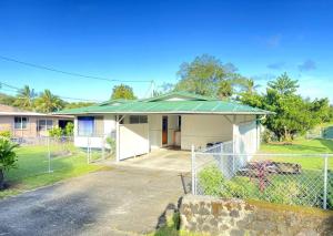 a house with a fence in front of it at THE HILO HOMEBASE - Charming 3 Bedroom Hilo Home, with AC! in Hilo