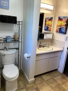 Łazienka z białą toaletą i umywalką w obiekcie THE HILO HOMEBASE - Charming 3 Bedroom Hilo Home, with AC! w mieście Hilo
