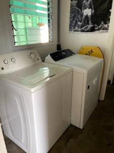 a white washing machine and a washer in a room at THE HILO HOMEBASE - Charming 3 Bedroom Hilo Home, with AC! in Hilo