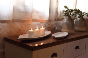 two candles on a table with two plates and vases at Mi capricho de Candeleda in Candeleda