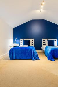 two beds in a room with blue walls at Huge 2 Bedroom 2 Bathroom Apartment - Northgate House in Ipswich