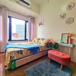 um quarto com uma cama e uma janela em Tropical Home at SMDC Air Residences Makati em Manila