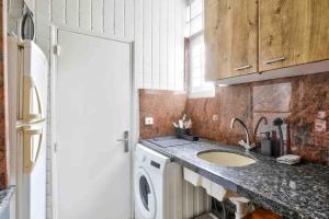 eine Küche mit einer Spüle und einer Waschmaschine in der Unterkunft Lumineux & calme Studio à ivry sur seine in Ivry-sur-Seine
