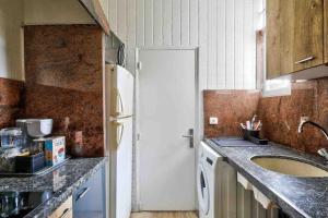 eine Küche mit einer Spüle und einem weißen Kühlschrank in der Unterkunft Lumineux & calme Studio à ivry sur seine in Ivry-sur-Seine