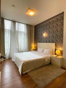 a bedroom with a large white bed and two lamps at Monte Carlo in Batumi