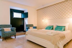 - une chambre avec un grand lit et deux chaises dans l'établissement Loving Chiado, à Lisbonne