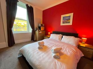 a red bedroom with a bed with towels on it at The waterfront in Tarbert