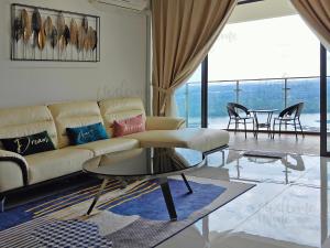 een woonkamer met een bank en een tafel bij Royal Strand, Country Garden Danga Bay Homestay by WELCOME HOME in Johor Bahru
