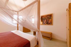 a bedroom with a bed with a canopy at Casa Louka in Saly Portudal
