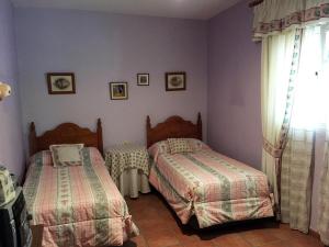 een slaapkamer met 2 bedden en een raam bij Casa Rosalejo by CasaTuristica in Ronda