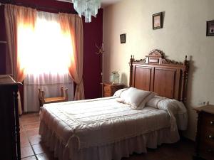 een slaapkamer met een groot bed en een raam bij Casa Rosalejo by CasaTuristica in Ronda