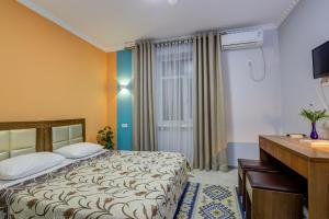 um quarto de hotel com uma cama e uma secretária em Viva Hotel em Bishkek