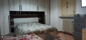 una camera con letto, cassettiera e tavolo di porta merlonia house grazioso monolocale a Forlì
