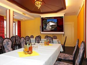 a dining room with a white table and chairs at Landhotel Alt-Jocketa in Pöhl