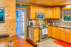 cocina con armarios de madera y mesa de madera en Tri-Mountain: Home base for exploring the mountains., en Packwood