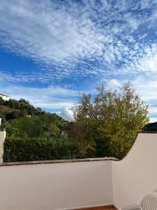 uma parede branca com uma árvore e um céu nublado em Casa Rural Bajadilla 5 em Atajate