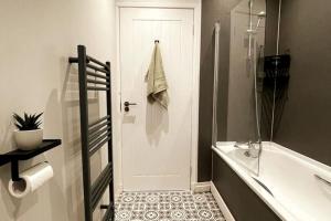 a bathroom with a shower and a tub and a toilet at New boutique 3 bedroom apartment in Hamilton in Hamilton
