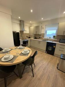 a kitchen with a wooden table and chairs in a kitchen at New boutique 3 bedroom apartment in Hamilton in Hamilton