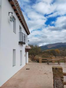 un patio con banco y mesa de picnic en LA CASA DE LA HUERTA Stylish family cottage in Malaga countryside, en Málaga 69 fotos más