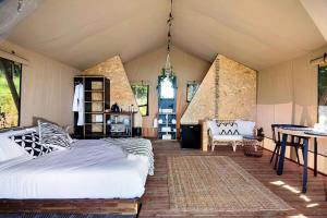 a bedroom with a bed and a table in a room at Cicada Luxury Camping in Kiama