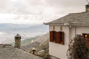 - un bâtiment blanc avec des fenêtres et une vue sur la vallée dans l'établissement The Fern House, à Makrinitsa