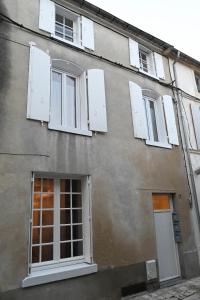 ein Gebäude mit weißen Fensterläden in der Unterkunft L'Acacia #Hyper-centre #Marché couvert in Cognac