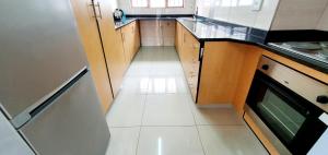 a small kitchen with a white tile floor and counters at Mermel 4 - Sleeps 6 - Overlooking Margate Lagoon! in Margate