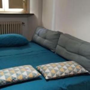 a bed with two pillows on top of it at porta merlonia house grazioso monolocale in Forlì