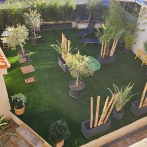 eine Luftansicht auf einen Garten mit Pflanzen und Bänken in der Unterkunft LE MAZET in Saint-Raphaël
