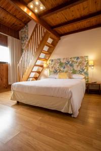 ein Schlafzimmer mit einem großen Bett und einer Treppe in der Unterkunft Hôtel & Restaurant La Ferme Du Pommeau in La Plaine des Palmistes