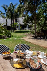 een houten tafel met eten erop bij Africa Lodge in Somerset West