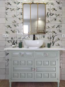 uma casa de banho com um lavatório branco e um espelho. em LA CASA DE LA HUERTA Stylish family cottage in Malaga countryside em Málaga