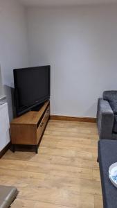 sala de estar con TV de pantalla plana y sofá en 3 Bedroom Home - Nerby City Centre, en Nottingham