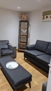 a living room with two blue couches and a table at 3 Bedroom Home - Nerby City Centre in Nottingham