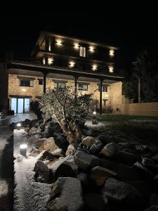 a building with a tree in front of a rock garden at night at Duruelo Mountain Suites in Duruelo de la Sierra