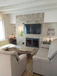 uma sala de estar com 2 sofás e uma televisão de ecrã plano em LA CASA DE LA HUERTA Stylish family cottage in Malaga countryside em Málaga
