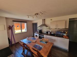 a kitchen with a wooden table with chairs and a tableablish at Appartement cosy, esprit montagne, au cœur du village in Chapelle-des-Bois