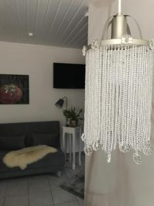 una lámpara de araña en la sala de estar con sofá en Ferienappartement Greiff, en Könen