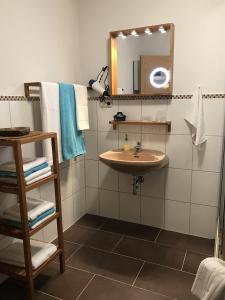 La salle de bains est pourvue d'un lavabo, d'un miroir et de serviettes. dans l'établissement Ferienappartement Greiff, à Könen