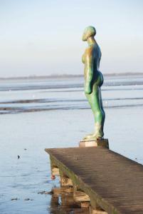een standbeeld van een vrouw op een pier bij Appenzeller, S u A , Ferienwohnung Dangaster Tied 2 in Dangast