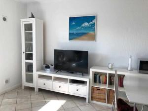 een woonkamer met een televisie op een wit entertainmentcentrum bij Appenzeller, S u A , Ferienwohnung Dangaster Tied 2 in Dangast