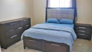 a bedroom with a bed with blue pillows and a dresser at Lux Sea View Camelot Village Discovery Bay in Discovery Bay +28 photos