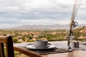 a table with a coffee cup and a glass of wine at Kapps Mountain Self Catering Accommodation in Voigtland