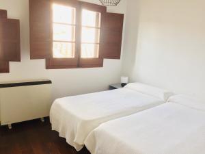 a bedroom with two beds and a window at El Ventanillo in Toledo