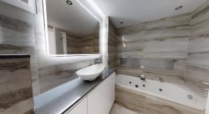 łazienka z umywalką, wanną i lustrem w obiekcie Luxury 2 bed Penthouse on Golf Course Murcia w mieście Sucina