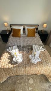 Una cama grande con dos flores blancas. en Patras Golden Suite en Patras