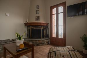 a living room with a fireplace and a television at The Fern House in Makrinitsa