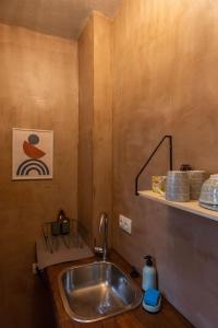 a bathroom with a sink and a shelf with towels at The Fern House in Makrinitsa