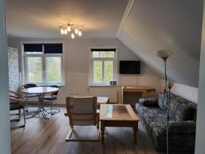 uma sala de estar com um sofá e uma mesa em Urlaub im blauen Haus em Sehestedt